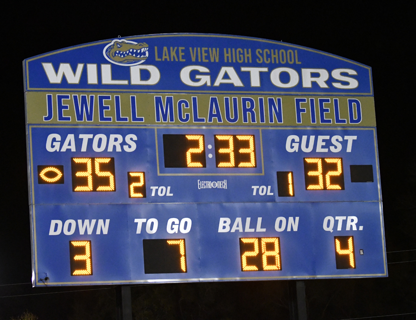 A blue football scoreboard shows Gators leading 35-32 against Guests, with 2:33 left in the 4th quarter, ball on the 28-yard line, 3rd down, 7 yards to go.