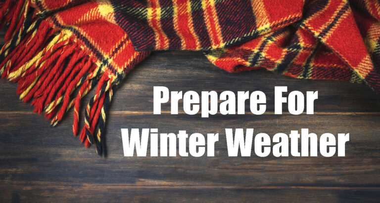 A red and yellow plaid scarf on a wooden surface with the text "Prepare For Winter Weather" in bold white letters.