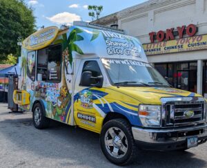 A colorful Tikiz Shaved Ice & Ice Cream food truck parked in front of a restaurant named Tokyo Little Tokyo Japanese Chinese Cuisine.