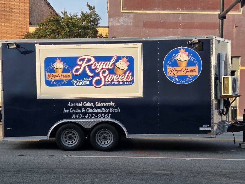 A blue food truck with "Royal Sweets" branding, advertising cakes, cheesecake, ice cream, chicken, rice bowls, and a phone number on the side.