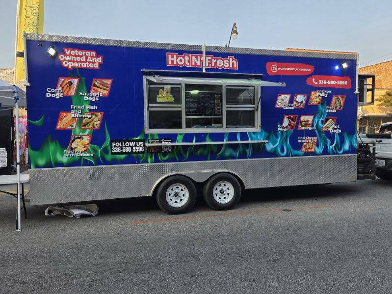 A blue food truck labeled "Hot N' Fresh" offers corndogs, sausage dogs, fried fish, shrimp, nachos, chicken, and chili cheese hot dogs, with contact information displayed.