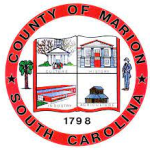 Seal of Marion County, South Carolina, featuring four quadrants with buildings, a tree, a person, and the year 1798, all within a red circular border.