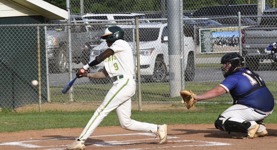 Baseball player in white uniform swings bat at a pitched ball, with a catcher in dark gear behind home plate, during a daytime game.