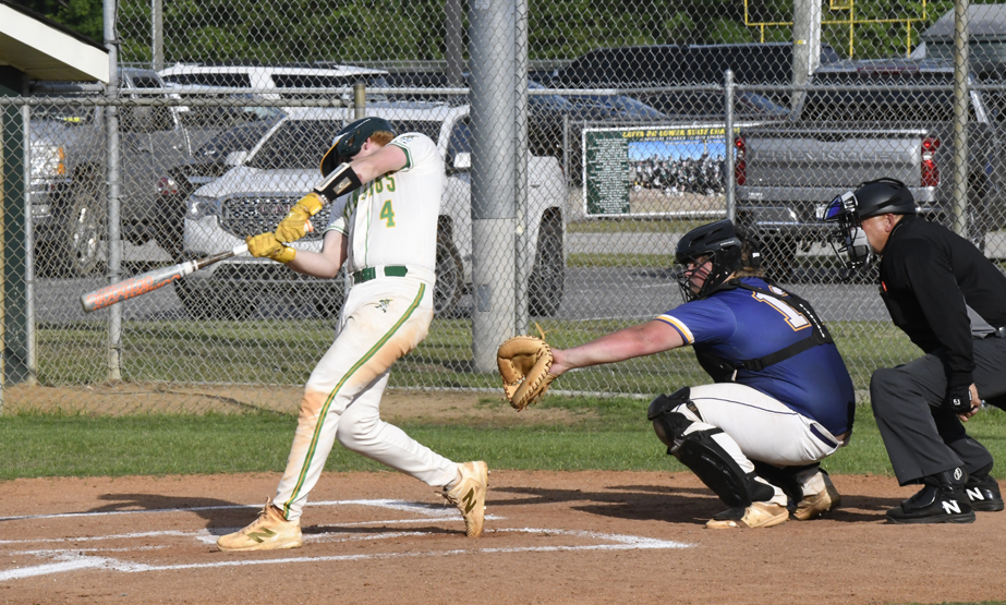 A baseball player swings at a pitch while a catcher and umpire watch closely behind home plate on a sunny day.