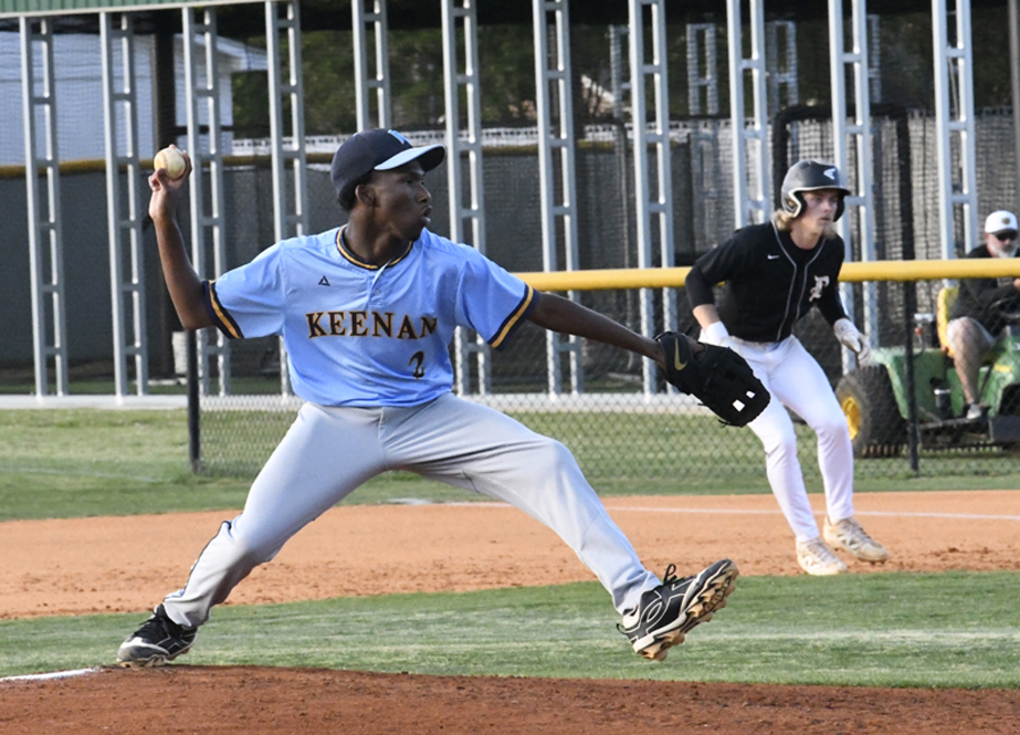 A baseball pitcher in a blue "KEENAN" jersey throws the ball while a baserunner in a black uniform prepares to run.