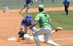 Baseball player slides into base as fielder attempts a tag, with other players and an umpire observing on a sunny field.