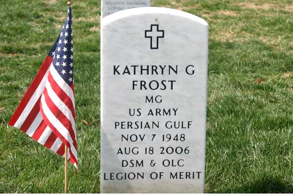 A gravestone for Kathryn G. Frost, US Army Major General, next to an American flag on grass, memorializing her service and honors.