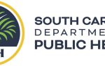 South Carolina Department of Public Health logo with blue text and a yellow circular design on the left.