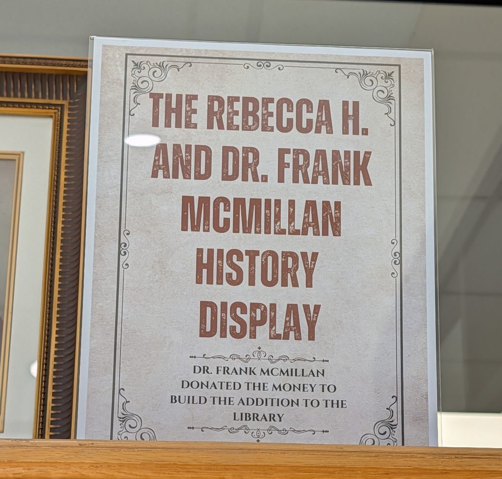 Sign reading: "The Rebecca H. and Dr. Frank McMillan History Display. Dr. Frank McMillan donated the money to build the addition to the library."
