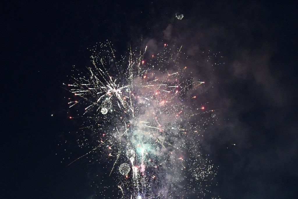 Colorful fireworks exploding in the night sky, with bright sparks and smoke creating a festive atmosphere.